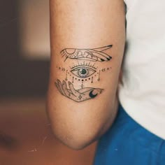 a woman's arm with an all seeing eye tattoo on the left side of her arm