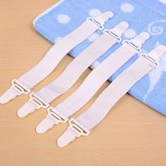 five white plastic straps are on top of a blue towel with polka dots and hearts