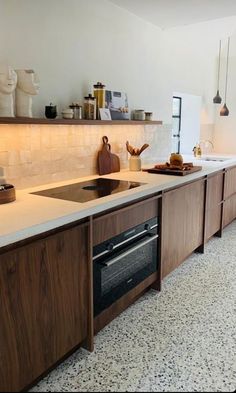 a kitchen with wooden cabinets and white counter tops, along with an oven in the center