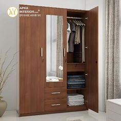 an open wardrobe with clothes hanging on the door and shelves next to it in a white room