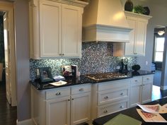 a kitchen with white cabinets and black counter tops