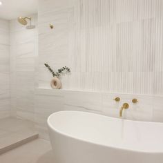 a white bath tub sitting next to a walk in shower