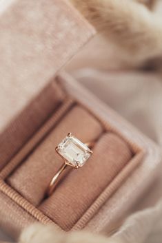 an engagement ring in a velvet box with fur on the floor and one piece of jewelry attached to it