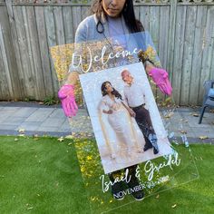 a woman holding up a sign that says, welcome to the bride and groom on it