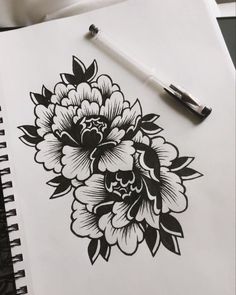 a drawing of flowers on paper next to a pen and ink pad with the same design