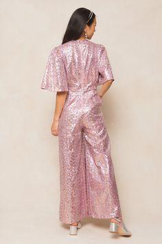 Get ready to sparkle and shine in our Bejeweled Jumpsuit! Made from pink sequin fabric, this women's jumpsuit features a flattering v-neckline and flirty short bell sleeves. The wide leg pants come equipped with convenient pockets and the exposed back zipper adds an extra touch of glam. Fully lined for added comfort. Ivy City Women's Bejeweled Jumpsuit Pink | Size: Medium Glamorous Pink Jumpsuits And Rompers For Party Season, Glamorous Pink Jumpsuits For Party Season, Pink Sequined Jumpsuits And Rompers For Party Season, Fitted Pink Sequined Jumpsuits And Rompers, Pink Fitted Jumpsuits And Rompers With Sequins, Pink Sequined Jumpsuits And Rompers For Summer, Glamorous Pink Jumpsuits And Rompers, Glamorous Festive Jumpsuits And Rompers For Parties, Glamorous Festive Party Jumpsuits And Rompers