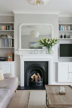 a living room filled with furniture and a fire place in front of a tv mounted on a wall