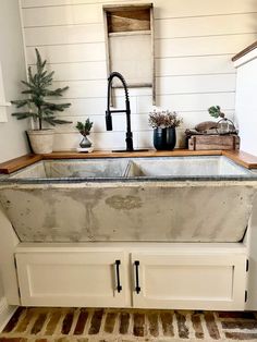 an old sink in the corner of a room with white walls and wood flooring