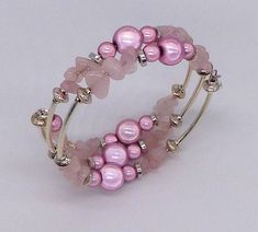 An eye catching bracelet made with pink quartz gemstones, pink Miracle beads and silver plated spacers. Rose Quartz is a symbol of unconditional love and is therefore  a perfect gift for Valentines day or for a wedding anniversary.  It is also supposed to help attract love and partnerships and therefore perfect if you are seeking a new relationship or as a gift for a friend. Miracle beads are acrylic, high gloss colourful beads with a mirror core.  As a result they 'glow' when they catch the light!  This bracelet uses  10mm and 6mm size beads. The bracelet is made with 2 strands of memory wire and will fit most wrists. Finished with a silver plated puffed heart and pink quartz charm.  Presented in an organza bag. A matching necklace and earrings are available - please ask for a custom orde Elegant Pink Jewelry Hand Wrapped, Elegant Hand Wrapped Pink Jewelry, Elegant Pink Hand Wrapped Jewelry, Adjustable Pink Pearl Bracelet With Spacer Beads, Elegant Pink Wire Wrapped Bracelets, Pink Beaded Round Pearl Bracelet, Hand Wrapped Rose Quartz Pink Jewelry, Hand Wrapped Pink Rose Quartz Jewelry, Pink Rose Quartz Hand Wrapped Jewelry