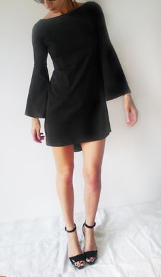 "Description: This minimalist black dress/tunic has wider sleeves and slight A-line body shape. The front bottom part of the dress is cut straight, and the back bottom part is longer and oval, so it gives it asymmetrical shape. It is tailored to fit loosely and fits all types of figures. Perfect for various occasions. Sizes: XS, S, M, L, XL, XXL & 3XL Care: turn the garment inside out for better washing results, machine wash cold, tumble dry low, warm iron if needed Fabric: elastic cotton je Sleek Long Sleeve Dress For Night Out, Elegant Black Asymmetrical Dress With Side Slits, Asymmetrical Dress With Side Slits For Work, Black Dress With Side Slits For Work, Black Workwear Dress With Side Slits, Black A-line Asymmetrical Dress For Formal Events, Black A-line Asymmetrical Formal Dress, Black A-line Asymmetrical Cocktail Dress, Black Work Dresses With Side Slits