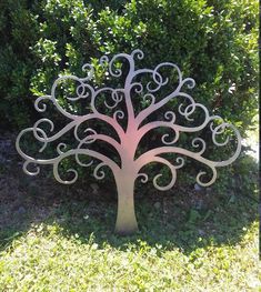 a metal tree sculpture sitting in the grass