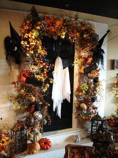 a decorated front door with pumpkins and other decorations