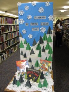 a book display in the middle of a library with books on it and snowflakes