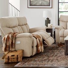 a living room with two recliners and a coffee table in front of a window