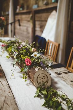 the table is covered with flowers and greenery