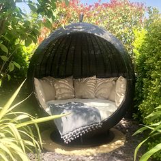 an outdoor bed in the middle of some bushes