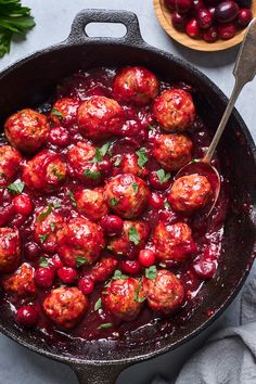 cranberry meatballs in a cast iron skillet with a spoon