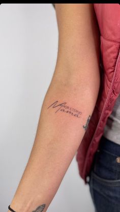 a woman with a tattoo on her arm that reads, mother and child in cursive writing