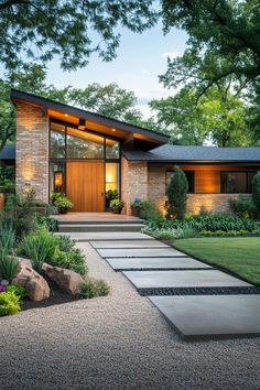 a modern house with stone walkway leading to the front door