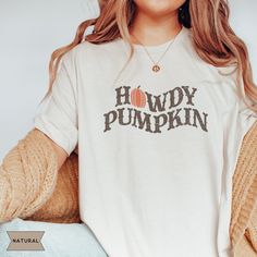 Keep the Halloween season a little spooky, country and western with our Howdy Pumpkin shirt. We hope you love this Western inspired Halloween crewneck as much as we do! PRODUCT DESCRIPTION ✿ Bella + Canvas tee ✿ 100% Cotton, Unlined, Light Fabric ✿ Unisex sizing; Relaxed fit with stretch ✿ Runs true to size; size up for an oversized look ✿ Direct-to-Garment printing (ink directly printed into the fabric = no fading or peeling off!) ✿ Colors may vary from different viewing devices CARE ✿ Machine Country Style Cotton Tops For Fall, White Western Shirt For Fall, Western Style White Shirt For Fall, Western Style Cotton Tops For Fall, Western Style Graphic Print Shirt For Fall, Western White Tops For Fall, White Western Tops For Fall, White Western Style Tops For Fall, Western Style Crew Neck Tops For Fall