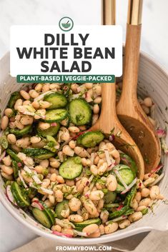 a bowl filled with beans, cucumbers and other veggies next to a sign that says dilly white bean salad