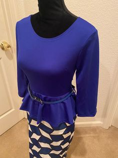 This is lovely brand new one piece dress that gives the illusion of a two-piece. It has a rounded neck line, a back zipper closure, 3/4 sleeve, belted waist, and made of polyester. The top portion is solid blue, and the skirt has a patterned blend of blue, white, and black. It’s an XSmall - Small with the following measurements: 26” waist30” bust34” hips40” length17” sleeve Ships immediately worldwide! Chic Blue Belted Dresses, Blue Belted Dress For Work, Blue Fitted Mini Dress With Half Sleeves, Blue Long Sleeve Belted Dress, Blue Belted Dress For Spring Workwear, Elegant Blue Belted Mini Dress, Blue Belted Long Sleeve Dress, Blue Fitted Mini Dress With 3/4 Sleeve, Blue Belted Mini Dress