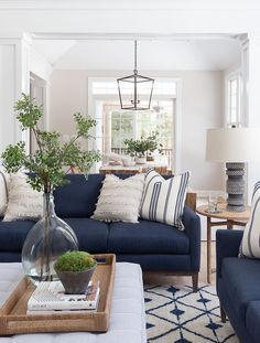 a living room with blue couches and pillows on top of the couch is featured in an instagram