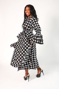 Indulge in the impeccable elegance of our 'Maria' Polka Dot Tiered Ruffle Sleeve Wrap Dress in black and white polka. Crafted from 100% wax cotton, this dress features a luxurious v-neck cut, long ruffled sleeves, and convenient side pockets. Its long floor length exudes sophistication and is available in one size ranging from medium to 2X for a perfect fit. Material: 100% Wax Cotton Care: Dry Clean Only The Model Wears A Size Medium Elegant Polka Dot Maxi Dress With Ruffles, Printed Wrap Dresses, Evening Formal, Ruffled Sleeves, Black Wrap Dress, Waxed Cotton, Dress First, African Print, Elegant Dresses