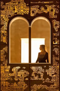 a woman standing in front of a window with words all over it