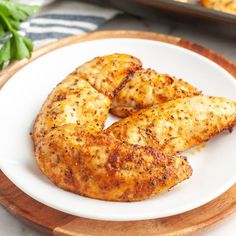 two pieces of chicken sitting on top of a white plate