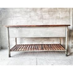 a wooden bench sitting in front of a cement wall