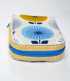 a close up of a small case on a white surface with blue and yellow designs