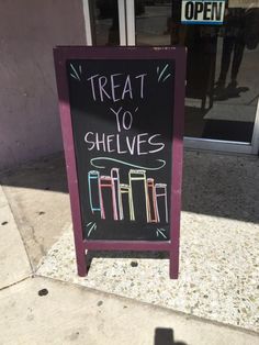 a chalkboard sign that says treat yo shelve's on the sidewalk