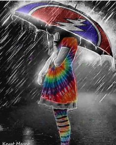 a woman standing in the rain holding an umbrella over her head and wearing rainbow socks