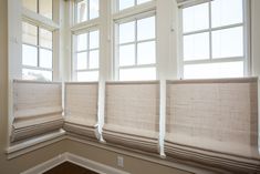 three windows in a room with wooden floors and white trim on the window sill