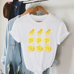 Are you looking for a lemon t-shirt for friends and family? Then this cute lemon tshirt good be a nice gift for their birthday. Surprise a lemon lover or garden lover with this unique shirt in the spring or summer. T-shirt: *This is an unisex t-shirt. Perfect fit for men and women. For women who like their t-shirt more tight than choose one size smaller. You can also choose your normal size for a little extra room to tie the t-shirt. *Measure one of your own shirts when it is laying flat. Measure just like in the picture and choose a size that comes close to your own shirt Care: *Wash in COLD water *Wash inside out *Hang out to dry *Do not iron the t-shirt How to choose the right size: *Take a t-shirt of your own that fits the way you like it. Lay it flat and measure just like in the pictu White T-shirt With Lemon Print For Summer, White T-shirt With Fruit Design For Spring, Yellow T-shirt With Lemon Print For Spring, White Short Sleeve T-shirt With Lemon Print, Casual Lemon Tops For Summer, White Crew Neck T-shirt With Lemon Print, White Short Sleeve Top With Lemon Print, Gift Yellow Graphic Print T-shirt, Yellow Graphic Print T-shirt For Gift