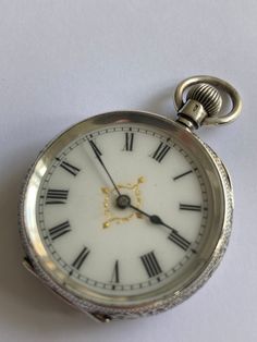 ANTIQUE Ladies Pretty Dial Solid Silver Victorian Fob Pocket Watch. Hallmarked 0.935 Continental Silver. Beautiful engraved floral & engine turned solid silver case having vacant shield cartouche to rear of case. Case. White enamel dial with black roman numerals. Guilded decoration to centre. Blue steel hands. Mechanical Swiss movement. Bow wound. Watch dimensions - 30mm diameter. Height inc. bow 45mm. This watch is sold with a 12 month guarantee from MBHI certificated watchmakers, established 1947. All watches will be serviced before shipping hence the 2-3 week dispatch. Please note - Watches are not waterproof unless otherwise stated and it is recommended not to wear them near water (i.e. washing hands, washing up, shower, swimming etc). Victorian Engraved Watch With Round Dial, Victorian Engraved Watches With Round Dial, Victorian Style Engraved Watch With Round Dial, Antique Engraved Watch Accessories, Victorian Silver Watch With Chronometer, Antique Silver Watch With Round Dial, Antique Silver Watches With Subdials, Silver Victorian Chronometer Watch, Silver Victorian Style Chronometer Watch