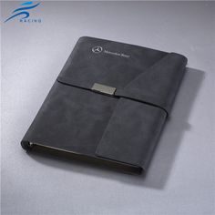 a black leather notebook with two silver metal clasps on the front and back cover