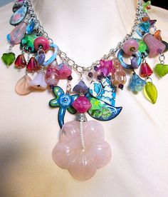 "This mixed media charm necklace has it all. Enameled copper moon, dragonfly, etched stars, butterflies, disks and drops with images of nature. It is also replete with handmade and vintage beads.  This conversation piece is finished off with a hand carved rose quartz dimensional flower. It measures 20\", but can be altered to your needs. This lives on a silver chain with a stunning sterling and opaline clasp.  This is one-of-a-kind, made  in my studio." Bohemian Multicolor Necklaces With Flower Charm, Bohemian Flower Charm Pendant Necklace, Vintage Multicolor Flower Pendant Jewelry, Bohemian Flower-shaped Nickel-free Necklace, Multicolor Flower-shaped Jewelry With Charms, Assemblage Necklace, Tigers Eye Necklace, Enameled Copper, Plastic Crafts