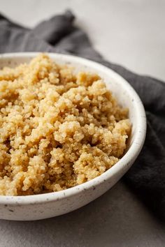 a white bowl filled with crumbs on top of a black cloth next to a napkin