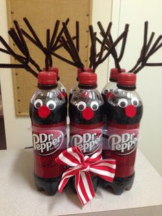 three soda bottles with reindeer antlers on them and a ribbon tied around the top