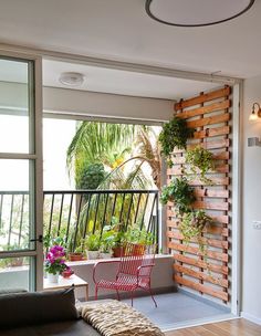 a living room filled with furniture next to a window covered in plants and potted plants