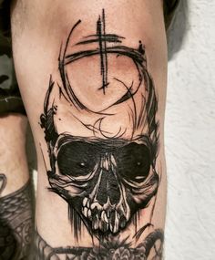 a man's leg with a skull and cross tattoo on it, in black ink