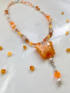 The Chroma Collection features 6 different necklaces! This necklace is adorned in a beautiful  collection of orange, white, and silver beads. it features a lovely hanging butterfly charm. All of my beaded necklaces are assembled by hand with love and are designed to be a unique look for whoever wears it! Art and beauty is for everyone. Thank you for visiting my garden. <3 Luxury Orange Spiritual Beaded Necklace, Luxury Spiritual Orange Beaded Necklace, Orange And Purple Jewerly Beads, Orange Beaded Dangle Necklaces, Orange Beaded Necklaces With Lobster Clasp, Butterfly Charm Necklaces With Round Beads For Gifts, Butterfly Charm Necklace With Round Beads For Gift, Orange Beaded Spiritual Crystal Necklace, Spiritual Orange Beaded Crystal Necklaces