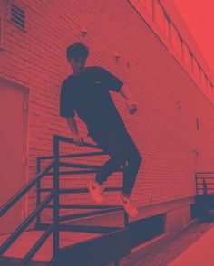 a man is jumping over the railing on his skateboard in front of a brick building