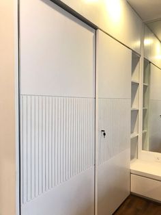 a bathroom with white walls and wooden floors