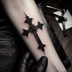 a person with a cross tattoo on their arm