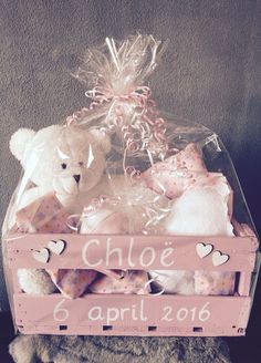 a teddy bear sitting on top of a wooden crate filled with stuffed animals in it