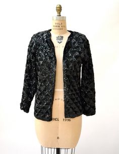 "Amazing Vintage Sequin Jacket Features: * fully embellished with black onyx sequins on wool body with woven lining * Basic neckline with long sleeves * Relaxed fit * great statement piece * Black lining and front hook and eye closure No Brand Sweater knit wool with synthetic lining Size 40, Fits like a Medium Era most likely the 50/60s In great condition, Beautiful jacket! Bust 40\" Bottom opening 39\" Body length from Shoulder seam 24\" Sleeve length from neck seam 27\" (can be taken out 1\") Sequin Winter Cardigan For Night Out, Winter Party Embellished Outerwear, Fitted Sequin Evening Cardigan, Glamorous Evening Cardigan For Winter, Fall Evening Sequined Outerwear, Glamorous Evening Winter Cardigan, Winter Embellished Long Sleeve Blazer, Glamorous Sequin Winter Cardigan, Glamorous Fitted Evening Cardigan