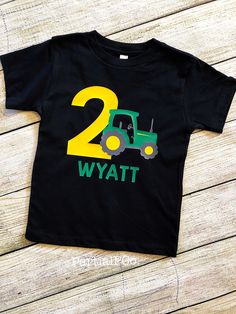 a black t - shirt with the number two on it and a tractor in front